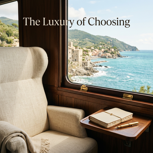 Ivory seat and cream journal beside a walnut railway window overlooking the Mediterranean, with The Luxury of Choosing headline