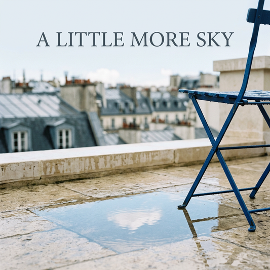 A cobalt-blue chair beside a rooftop puddle reflecting a white cloud beneath the headline A Little More Sky